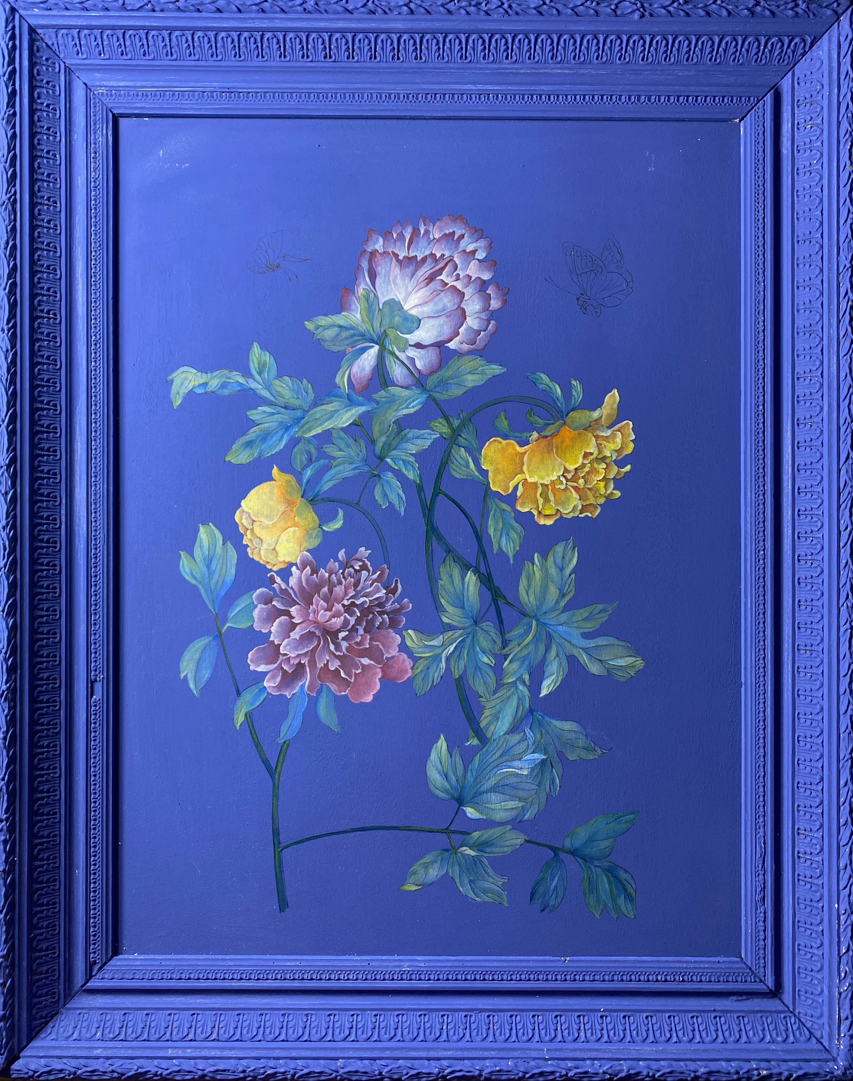 A framed painting featuring four painted flowers in pink, yellow, and white with green leaves on a deep blue background, enclosed in a matching blue ornate frame.